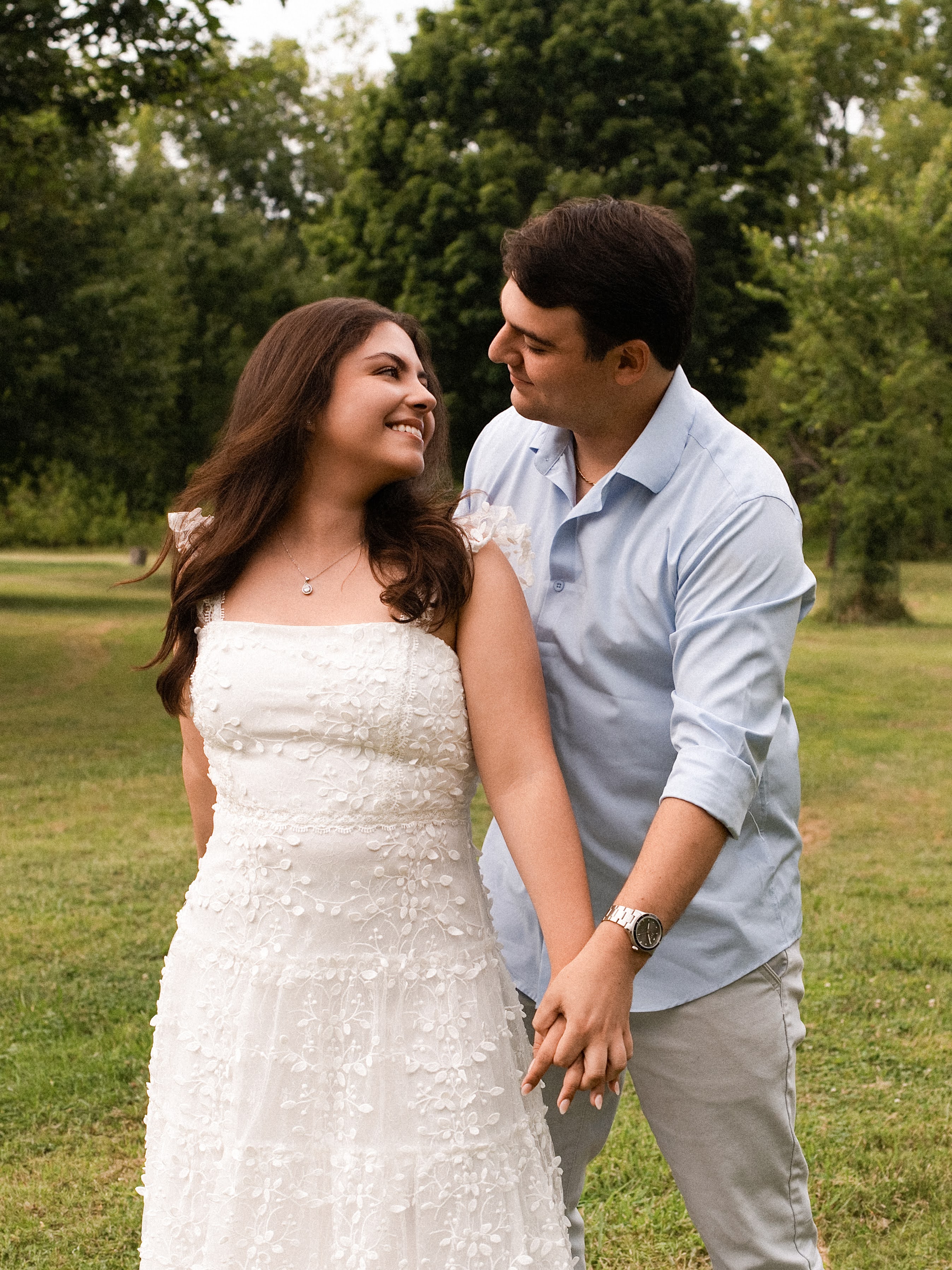 Carolina e Jason sorrindo um para o outro em um campo